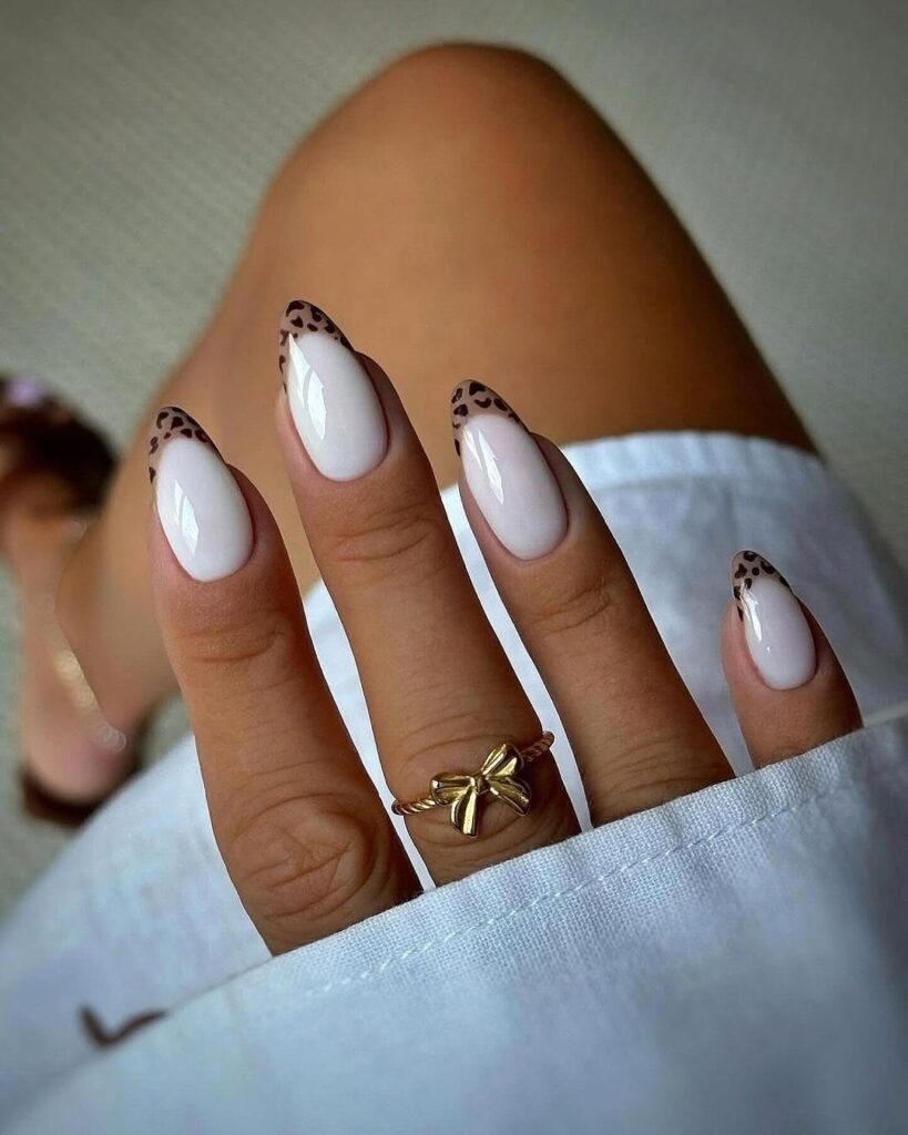 Nude pink almond nails with leopard French tips for bold fashion nail ideas