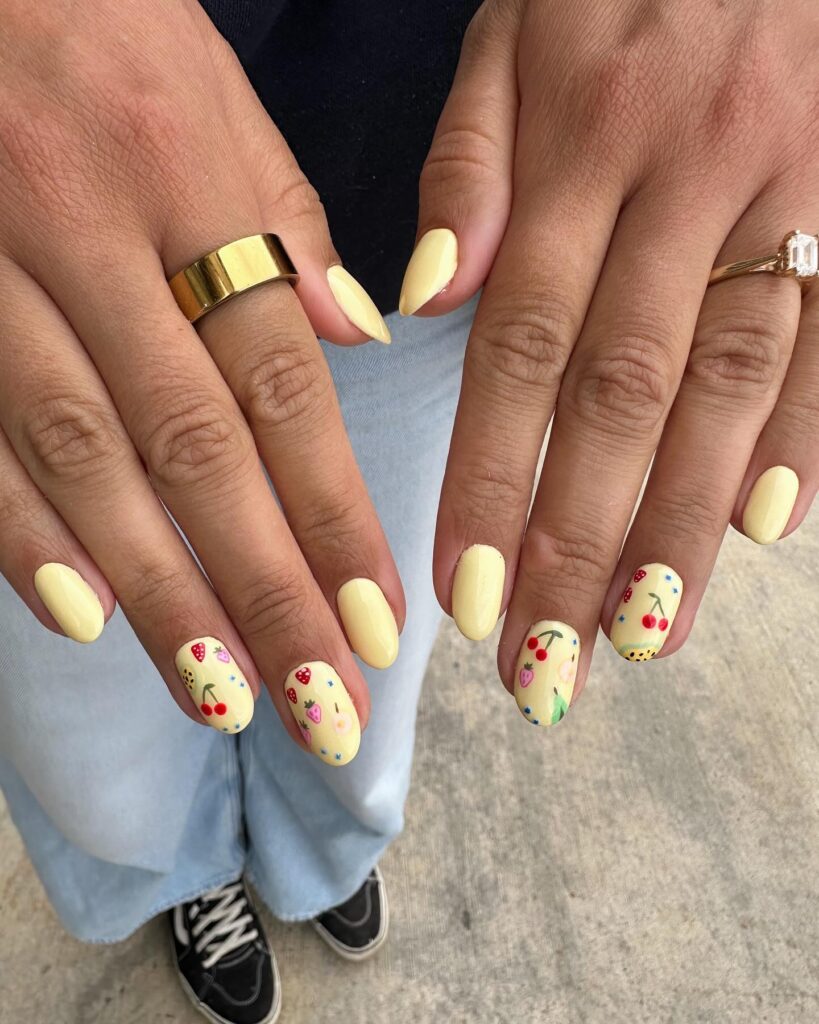 Pastel Yellow Almond Nails with Fruit Art for a Fun and Playful Summer Style