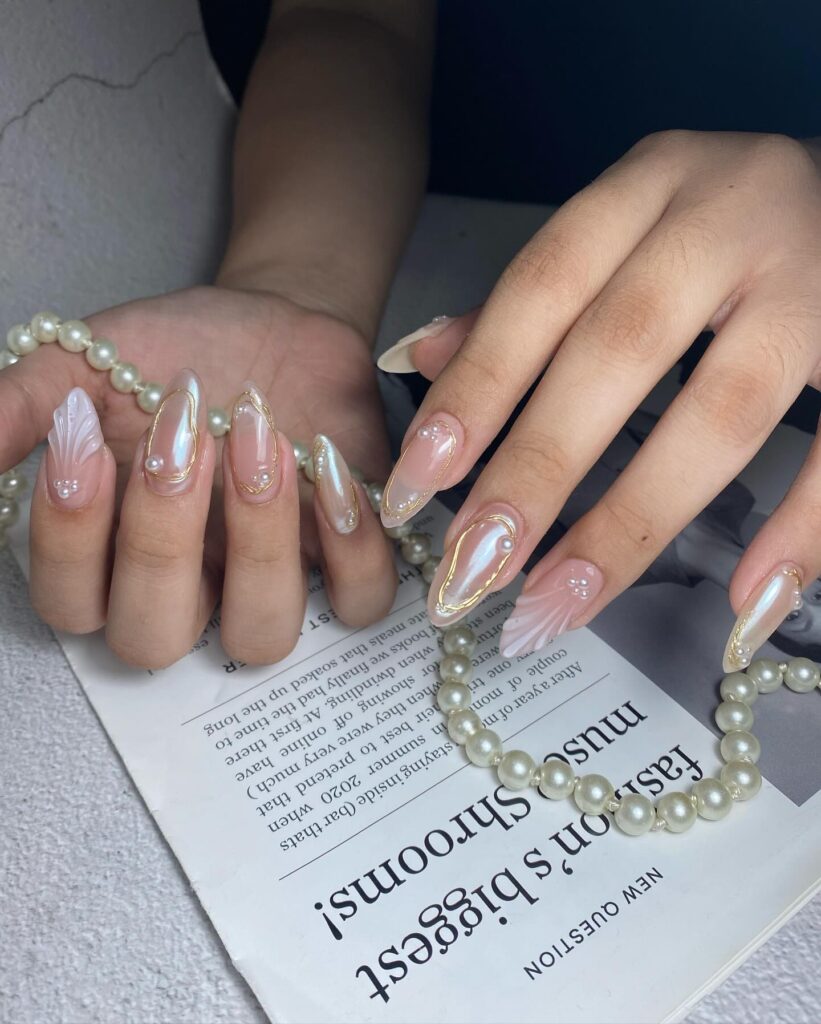 Pearlescent Nude Almond Nails with Golden Edges and 3D Pearls for a Luxe Graduation Look
