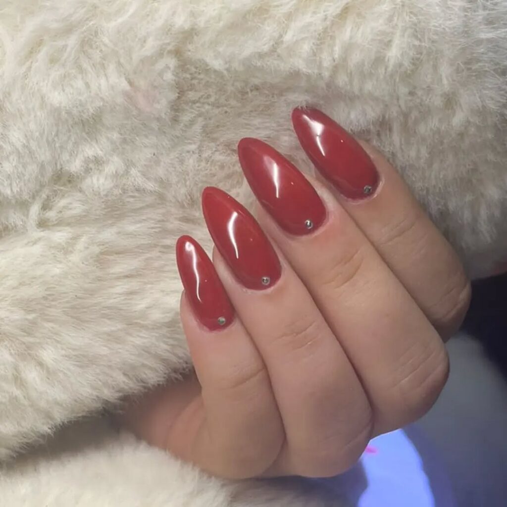 Red Almond Nails with Delicate Gem Accents for Subtle Glam