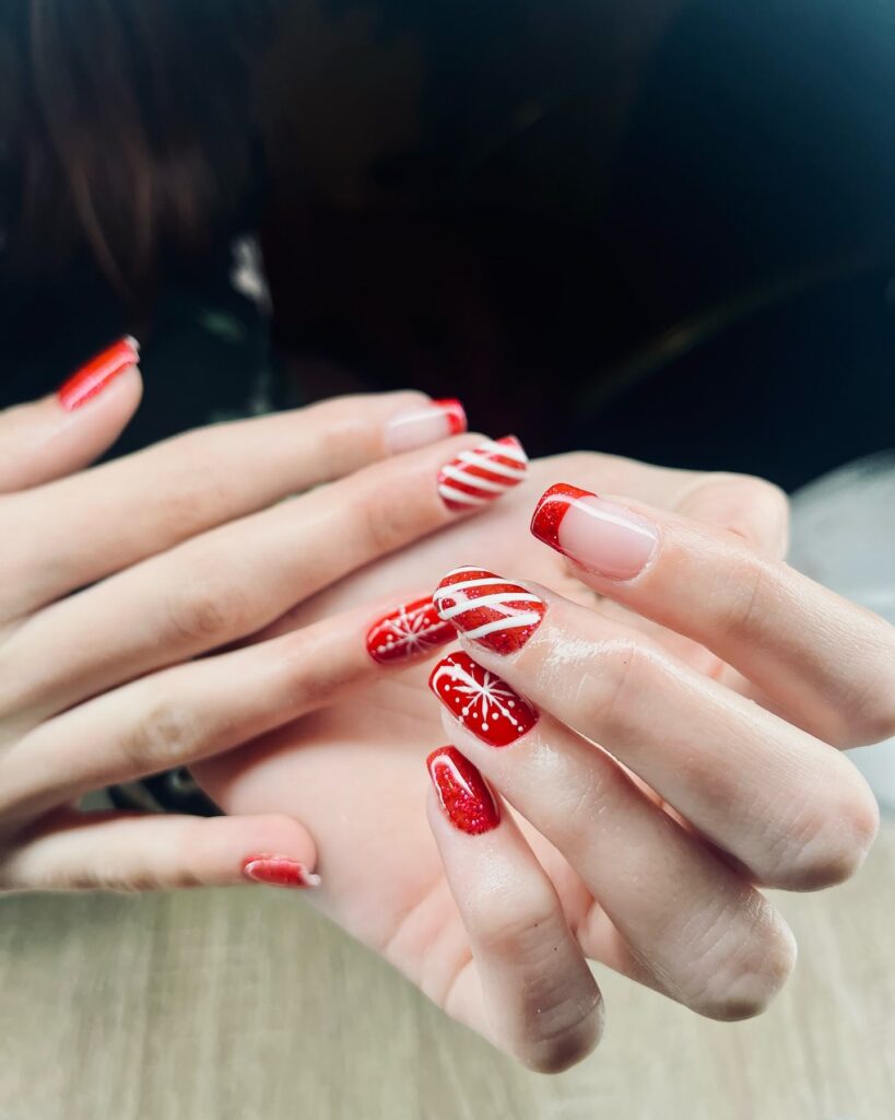 Red Almond Nails with Snowflakes and Glittery French Tips for a Festive Winter Look