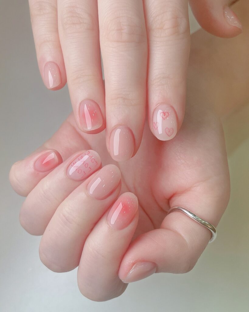 Romantic pink almond nails with hearts and gradient tips soft love themed nail ideas