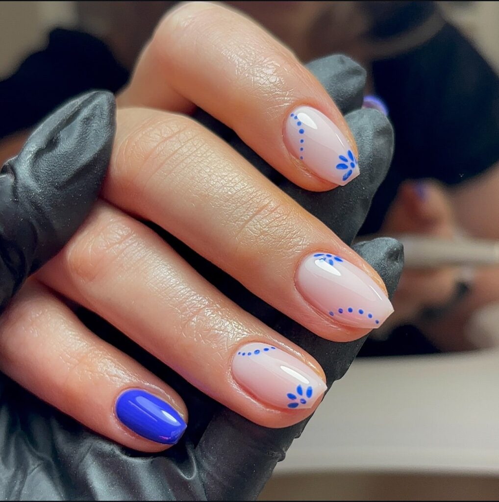 Short Almond Nude Nails with Blue Floral Tips and Dot Details for a Chic Summer Design