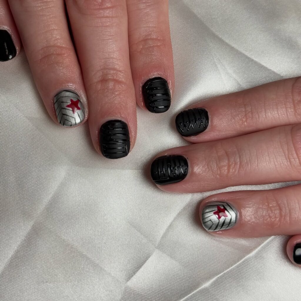 Short matte black nails with metallic silver and red star accent inspired by winter soldier nail design