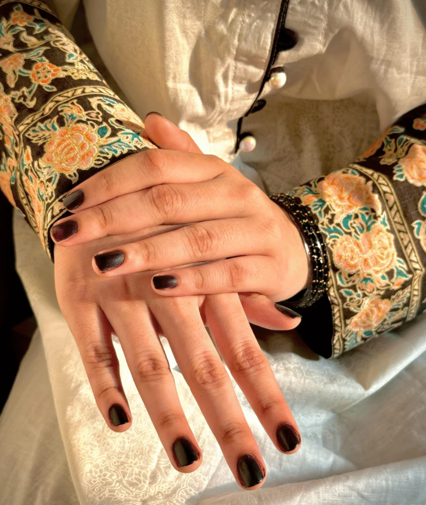 Short rounded black cherry nails with subtle burgundy tones for a timeless and elegant manicure look