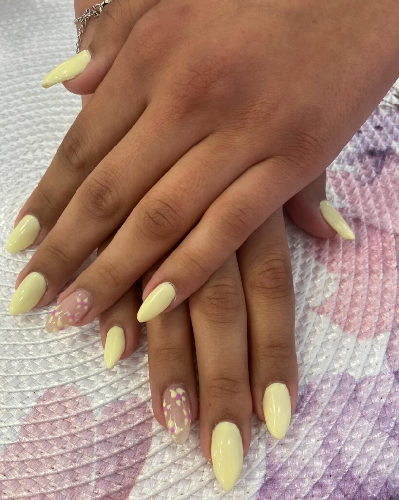 Soft Yellow Almond Nails with Delicate Floral Accents for a Garden Inspired Look