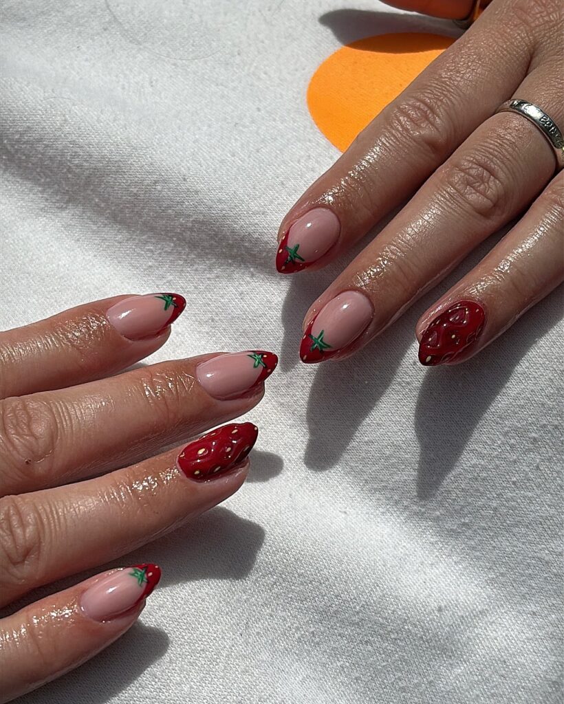 Strawberry-Inspired Almond Nails with Red Tips and Fruit Art for a Sweet Summer Feel