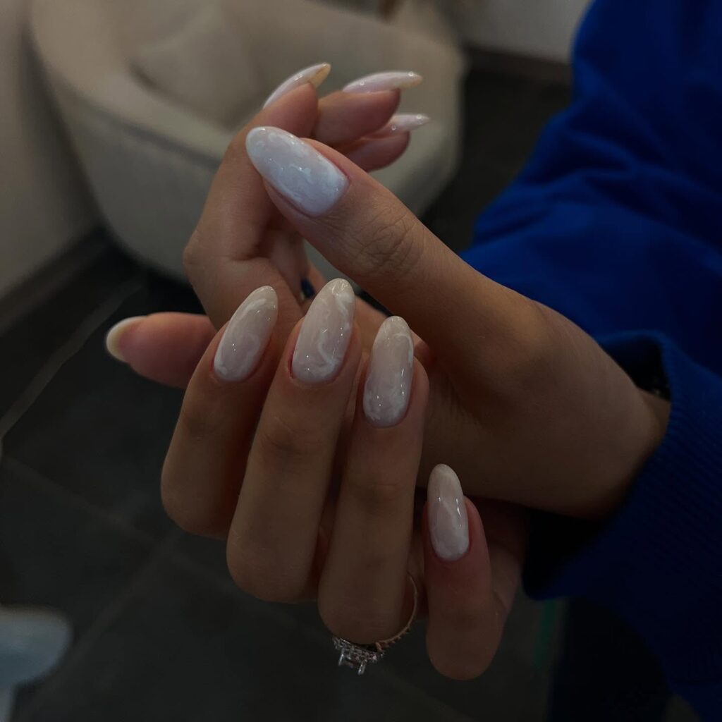 Translucent Nude Almond Nails with White Marble Swirls